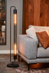 Calixt Svart gulvlampe Fra Lucide - Med sin rene og slanke design, og for eksempel to gl&oslash;delamper innelukket i en sylinder av nett og sitt metalliske utseende, passer den perfekt inn i et moderne interi&oslash;r.