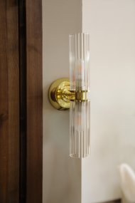 Rimini 35cm Messing baderomslampe Fra Markslöjd - Rimini er en elegant vegglampe med stilige detaljer i messingfinish og to avlange skjermer i klart, riflet glass.