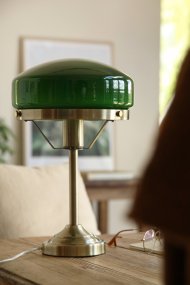 Aurelia 40cm Antikk messing/grønn bordlampe Fra Markslöjd - Den antikk messingfargede metallbasen er kombinert med en mykt formet skjerm i gr&oslash;nt glass, noe som gir lampen et klassisk og stilig uttrykk.