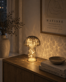 Svamp 23cm Grå bordlampe Fra Pixie Design - Den er utstyrt med en timer og en praktisk 5-trinns dimmer for &aring; justere lyset etter behov, noe som gj&oslash;r den perfekt for b&aring;de arbeidsbelysning og koselig kveldsbelysning.