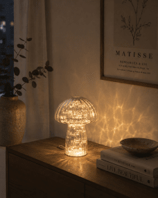 Svamp 23cm Blå bordlampe Fra Pixie Design - Den er utstyrt med en timer og en praktisk 5-trinns dimmer for &aring; justere lyset etter behov, noe som gj&oslash;r den perfekt for b&aring;de arbeidsbelysning og koselig kveldsbelysning.