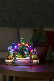Mekanisk Juledekorasjon Med Dyrehage 20cm Flerfarget Fra Konstsmide - Denne mekaniske julepynten tilbyr p&aring; en fargerik scene med 19 varmhvite LED-lys, musikk, dyr og nissen rundt et glitrende juletre.