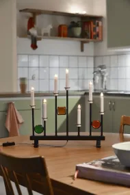 Candelabra 7 Lights Svart Fra Konstsmide - De syv lysene er innrammet av dekorative fargede glassdetaljer i gr&oslash;nt, r&oslash;dt og rav, som skaper en elegant og festlig atmosf&aelig;re.