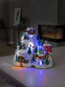 Mekanisk Juledekorasjon Med Fjellandskap 28cm Flerfarget Fra Konstsmide - Bli med til et glitrende vinterlandskap p&aring; fjellet med denne mekaniske julepynten!