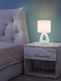 Triangle 30cm Hvit bordlampe Fra Globo Lighting - Den triangelformade basen med ett stilrent utskuret h&aring;l ger ett modernt intryck, medan den ovala textilsk&auml;rmen i vit f&auml;rg sprider ett behagligt och j&auml;mnt ljus.