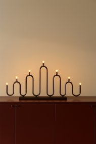 Noel 7 Bronse Fra Globen Lighting - Det myke, b&oslash;lgete designet er laget av metallr&oslash;r som er b&oslash;yd for h&aring;nd p&aring; forskjellige niv&aring;er og gir en moderne tolkning av den klassiske adventslysestaken.