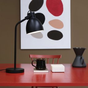 Coast 52cm Svart skrivebordslampe Fra Dyberg Larsen - Laget av metall med hvitt interiør gir den god belysning i kombinasjon med den bevegelige skjermen.