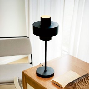 Stoke 50cm Svart bordlampe Fra Dyberg Larsen - Lampen passer perfekt som både en skulpturell interiørdetalj og lyspunkt, for eksempel på kjøkkenet, på skrivebordet eller i stuen.