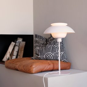 Opus 48cm Matt hvit bordlampe Fra Dyberg Larsen - Den hvite metallstangen og flate basen, sammen med den diskrete hvite tekstilsnoren, gir stabilitet og et snev av raffinement.