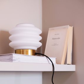 Diva 15cm Messing bordlampe Fra Dyberg Larsen - Den elegant designade Diva bordslampan i m&auml;ssing ger en sofistikerad touch till varje hem och &auml;r ett konstverk som tillf&ouml;r liv och sk&ouml;nhet till rummet.