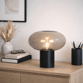 Alba 32cm Svart/Røkt bordlampe Fra Nordic Lighting - Den svarte metallbasen gir et stabilt og elegant uttrykk, mens den r&oslash;ykfargede glassskjermen skaper et mykt og stemningsfullt lys.