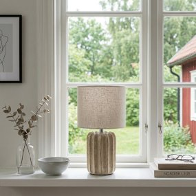 Flint 33cm Beige bordlampe Fra Cottex - Lampebasen er kombinert med en beige tekstilskjerm som skaper en myk og harmonisk helhet.