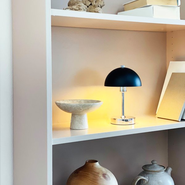 Malmø LED 23cm Krom bærbar Fra Dyberg Larsen - Den svart- och kromf&auml;rgade metallen ger en elegant touch, och med sin kompakta storlek passar den perfekt p&aring; nattduksbord, skrivbord eller som dekorativ belysning.