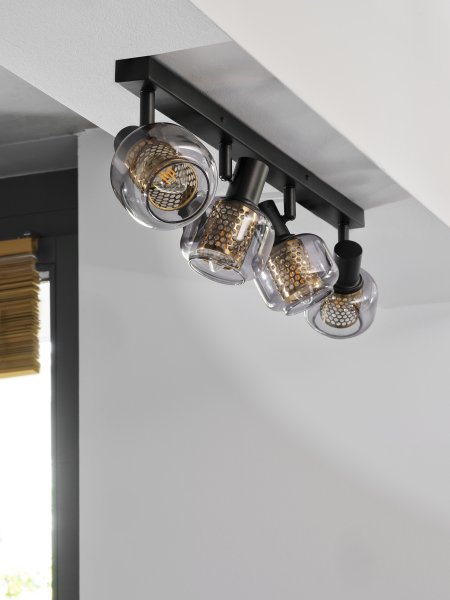 Firefly 4 Svart spotlight Fra Ledvance - De r&ouml;rliga spotlightsen med sk&auml;rmar av gr&aring;tonat glas i kombination med de guldiga detaljh&ouml;ljet som omfamnar ljusk&auml;llorna bidrar med en elegans till rummet.