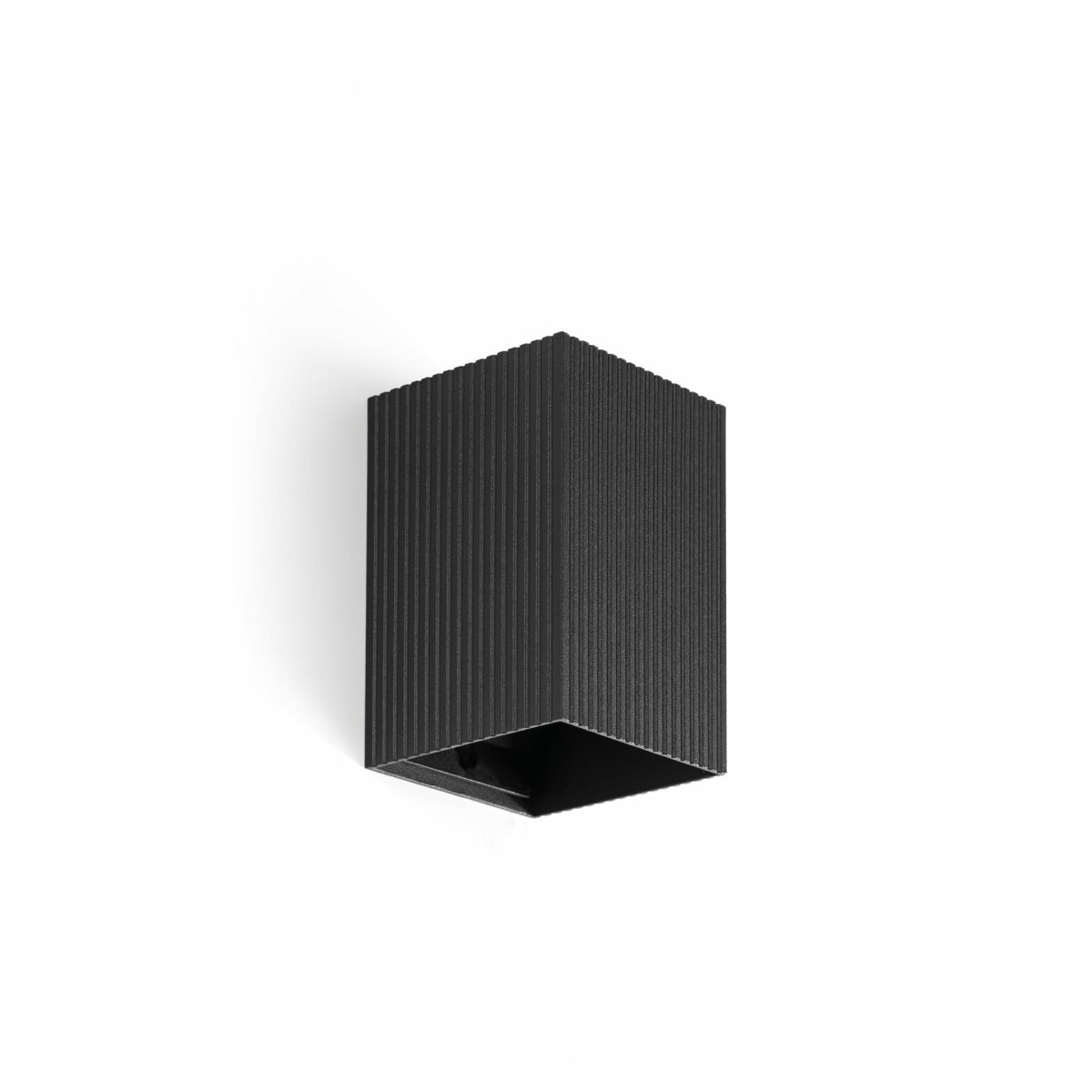 Lune 10cm Svart rillet vegglampe Fra Faro Barcelona - Lune er en firkantet vegglampe med en svart ribbet overflate som kombinerer funksjon og form.