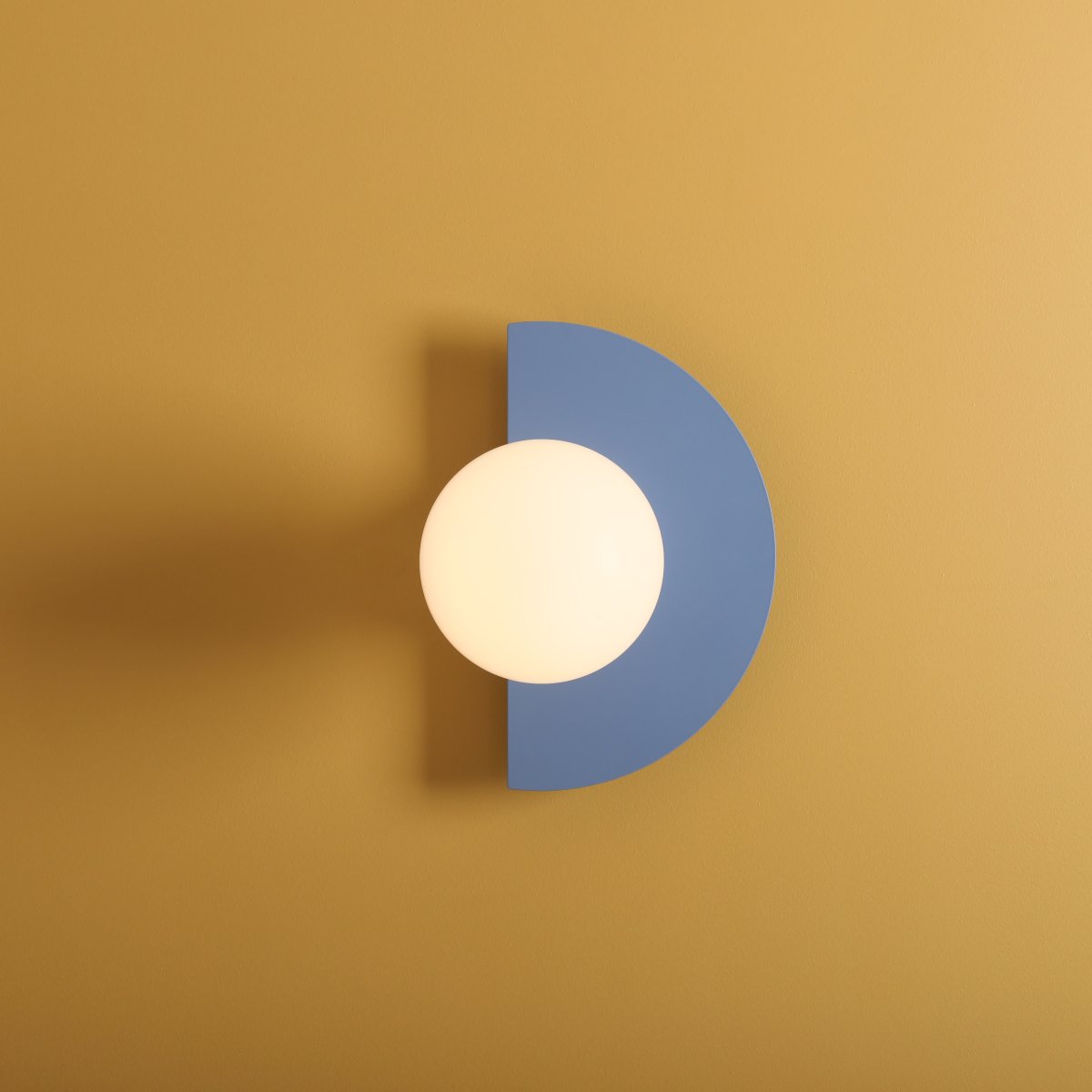 Loop 28cm Blå vegglampe Fra Artera - Den halvformede basen i subtil bl&aring; tone er vakkert kontrastert av den runde opale globusen, som gir et mykt og behagelig lys.