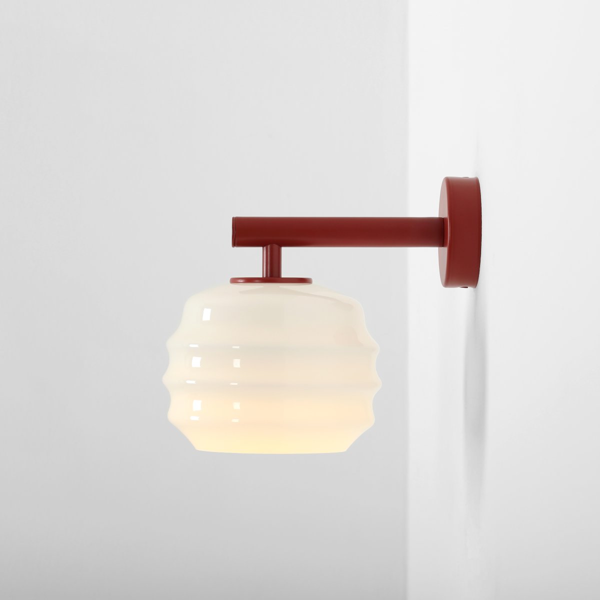 Puff 23cm Burgunder vegglampe Fra Artera - Den dekorative skjermen i hvitt opalglass har en bølget form som gir lampen et lekent og elegant uttrykk.