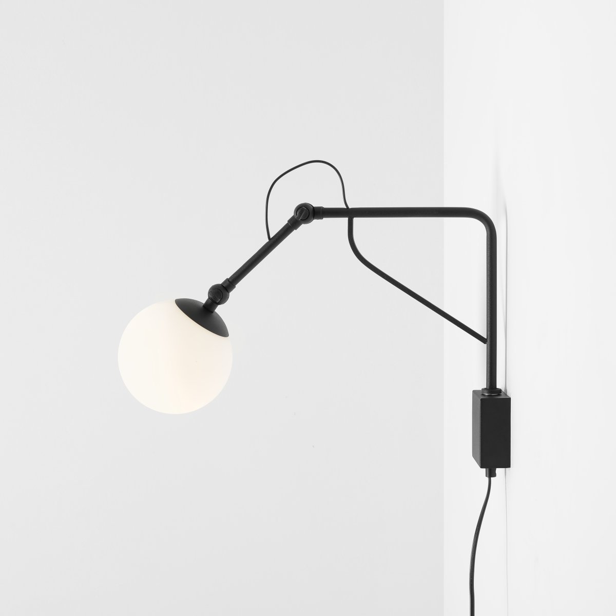 Soho 50cm Svart vegglampe Fra Artera - Lampen har en stilig matt svart metallramme og en opal globus som sprer et mykt, varmt lys, og skaper en innbydende atmosfære i alle rom.