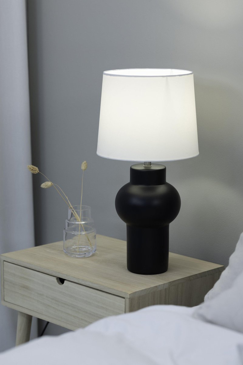 Shape 46cm Svart bordlampe Fra Markslöjd - Shape bordlampen er en stilig sort lampe med en vakker keramisk sokkel og en hvit tekstilskjerm som skaper et mykt lys.