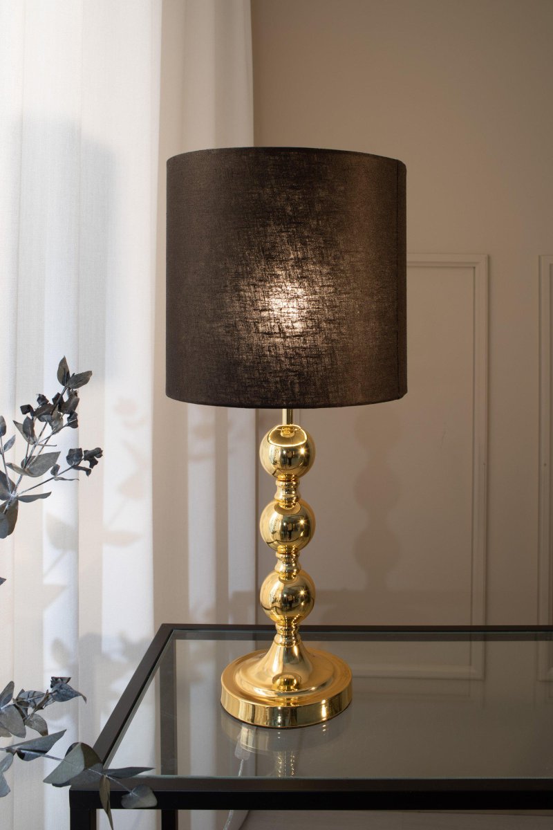 Octo 57cm Messing bordlampe Fra Markslöjd - Octo er en elegant bordlampe med svart linskjerm og en messingfarget lampefot i form av tre myke, runde globuser.