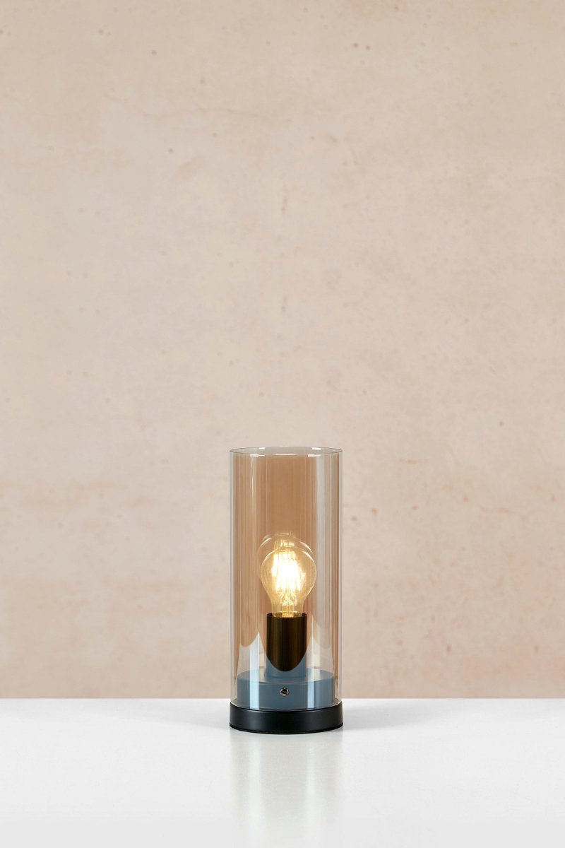 Post 38cm Rav bordlampe Fra Markslöjd - Post er en stilig sylindrisk bordlampe, med sokkel i matt sort metall og en ravfarget glassskjerm.