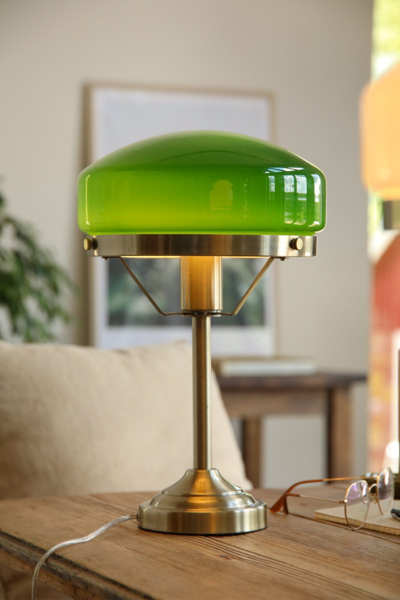 Aurelia 40cm Antikk messing/grønn bordlampe Fra Markslöjd - Den antikk messingfargede metallbasen er kombinert med en mykt formet skjerm i gr&oslash;nt glass, noe som gir lampen et klassisk og stilig uttrykk.