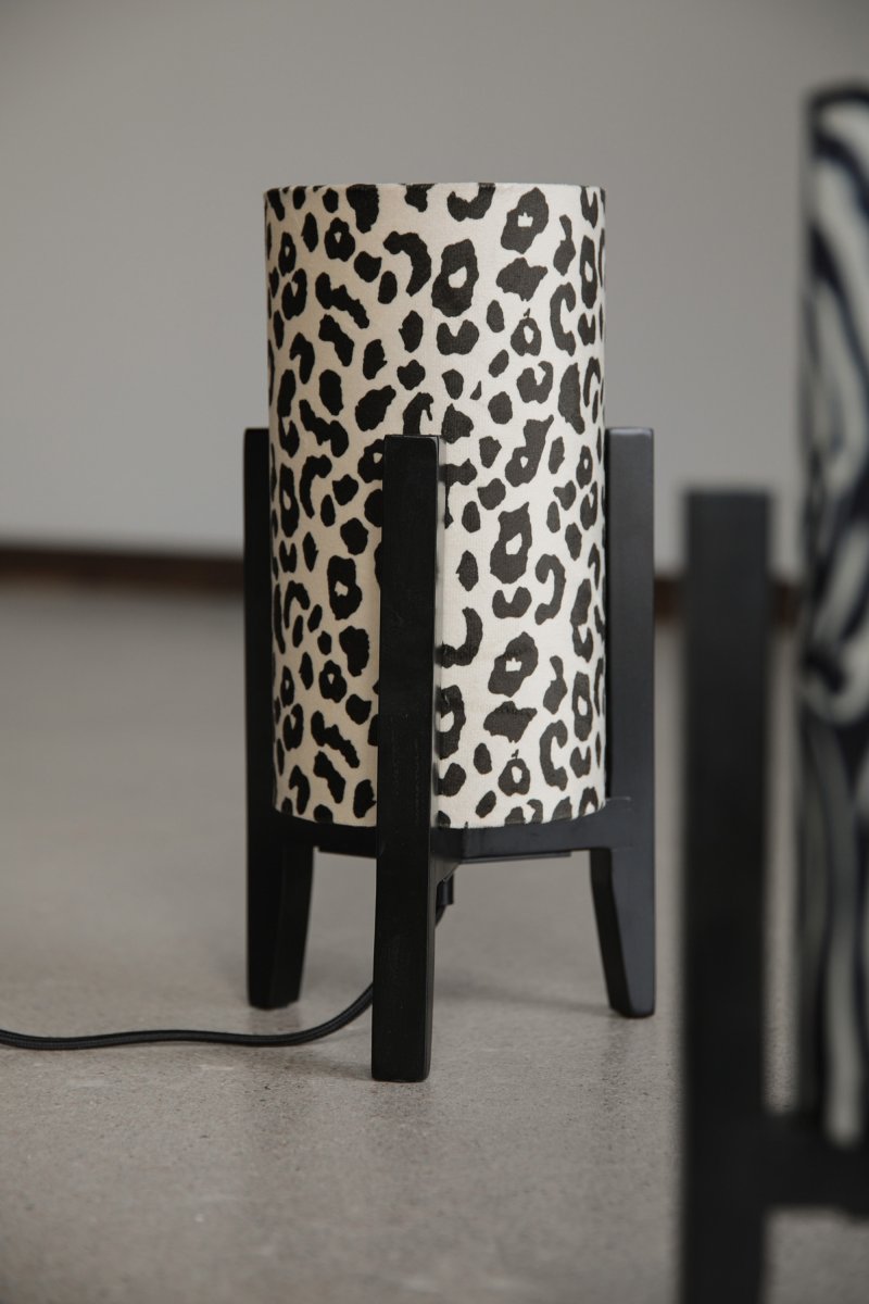 Eruca 34cm Leopard bordlampe Fra Markslöjd - Lampefoten i svart tre er kombinert med en sylindrisk tekstilskjerm i off-white og brunt leopardm&oslash;nster, noe som gir lampen en trendy og personlig karakter.