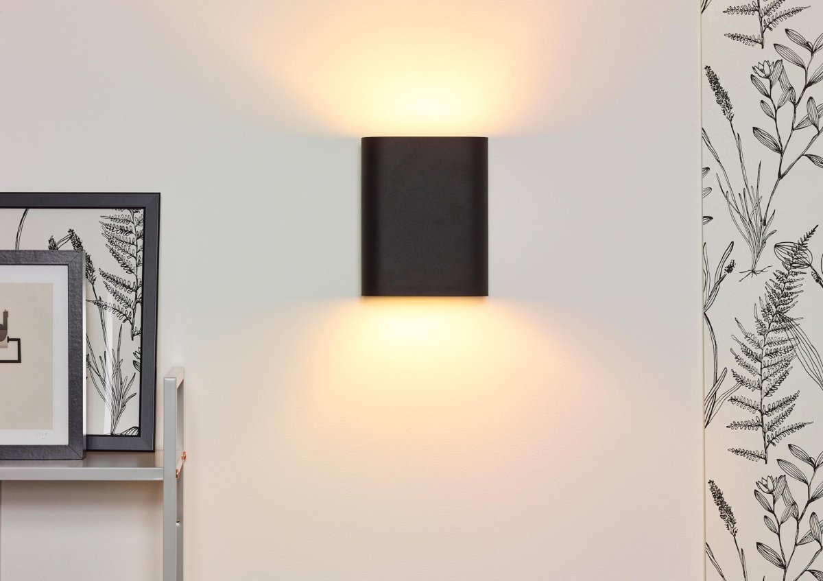 Ovalis 20cm Svart vegglampe Fra Lucide - Ovalis skaper en vakker timeglassformet lyseffekt p&aring; veggen, og med sitt gylne innside skaper den en varm atmosf&aelig;re i rommet.