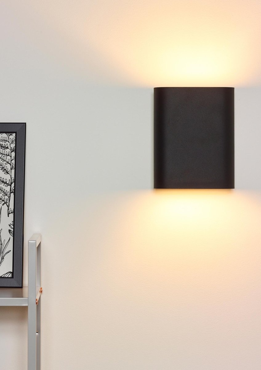 Ovalis 20cm Svart vegglampe Fra Lucide - Ovalis skaper en vakker timeglassformet lyseffekt p&aring; veggen, og med sitt gylne innside skaper den en varm atmosf&aelig;re i rommet.