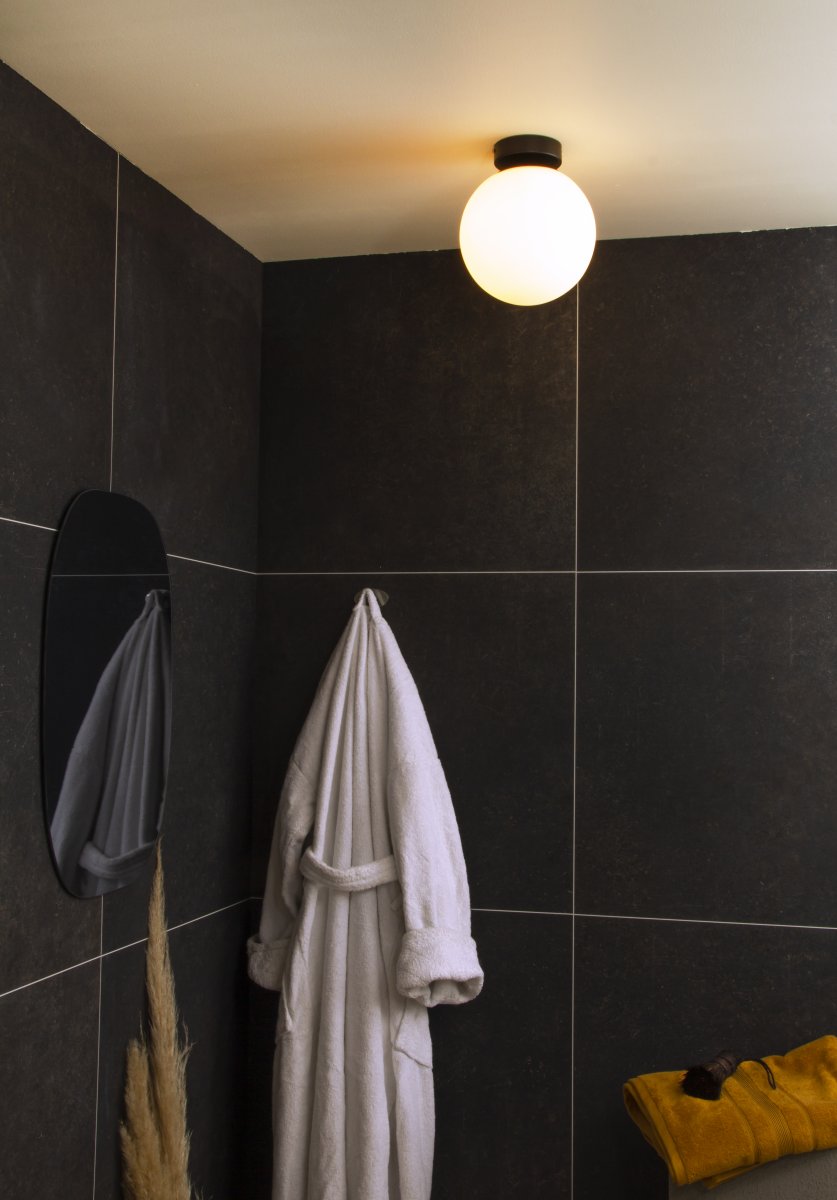 Lido Ø20 Svart baderomslampe Fra Aneta Lighting - Den mattsvarte metallrammen er kombinert med en rund opalglassskjerm som sprer et mykt og behagelig lys.