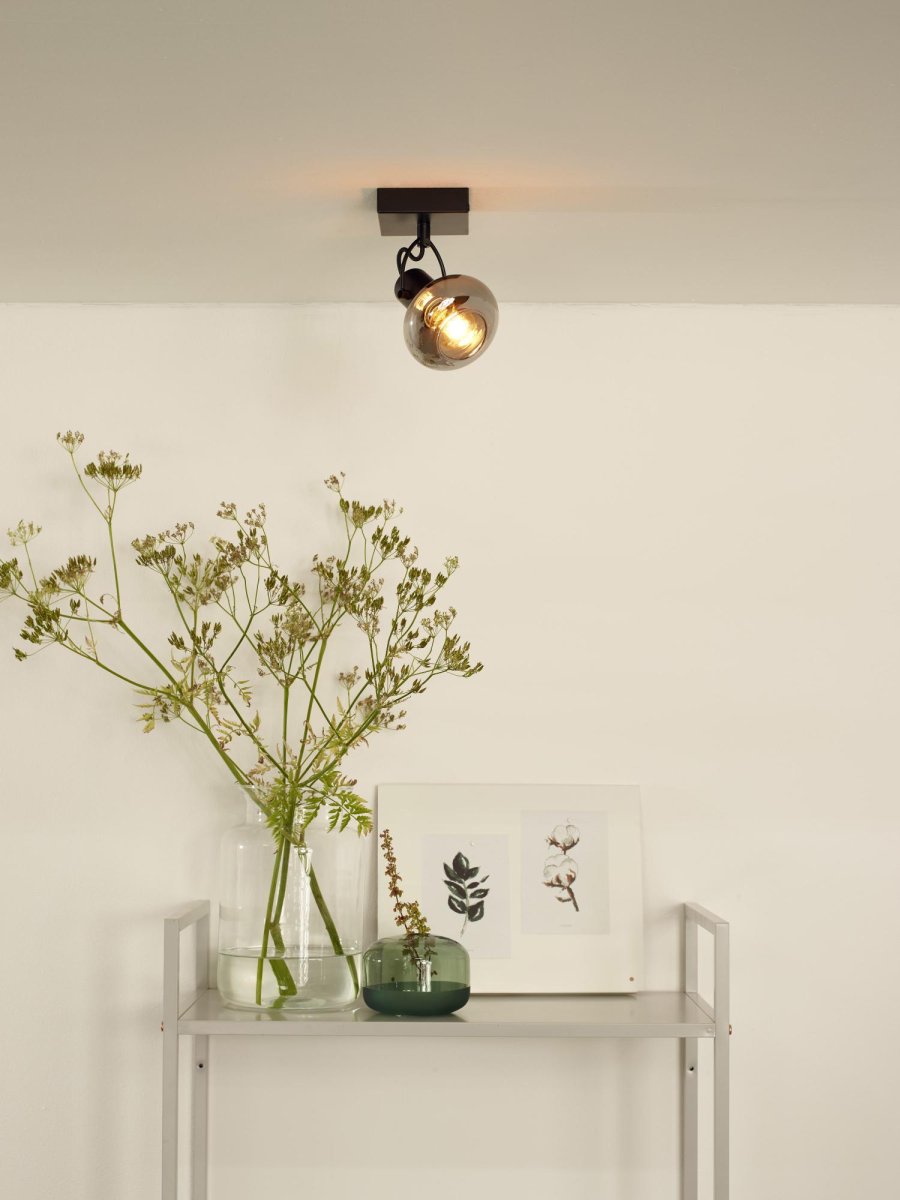 Madee Svart spotlight Fra Lucide - Klasse og eleganse er kombinert i et unikt design med en metallsokkel og en glasslampeskjerm.