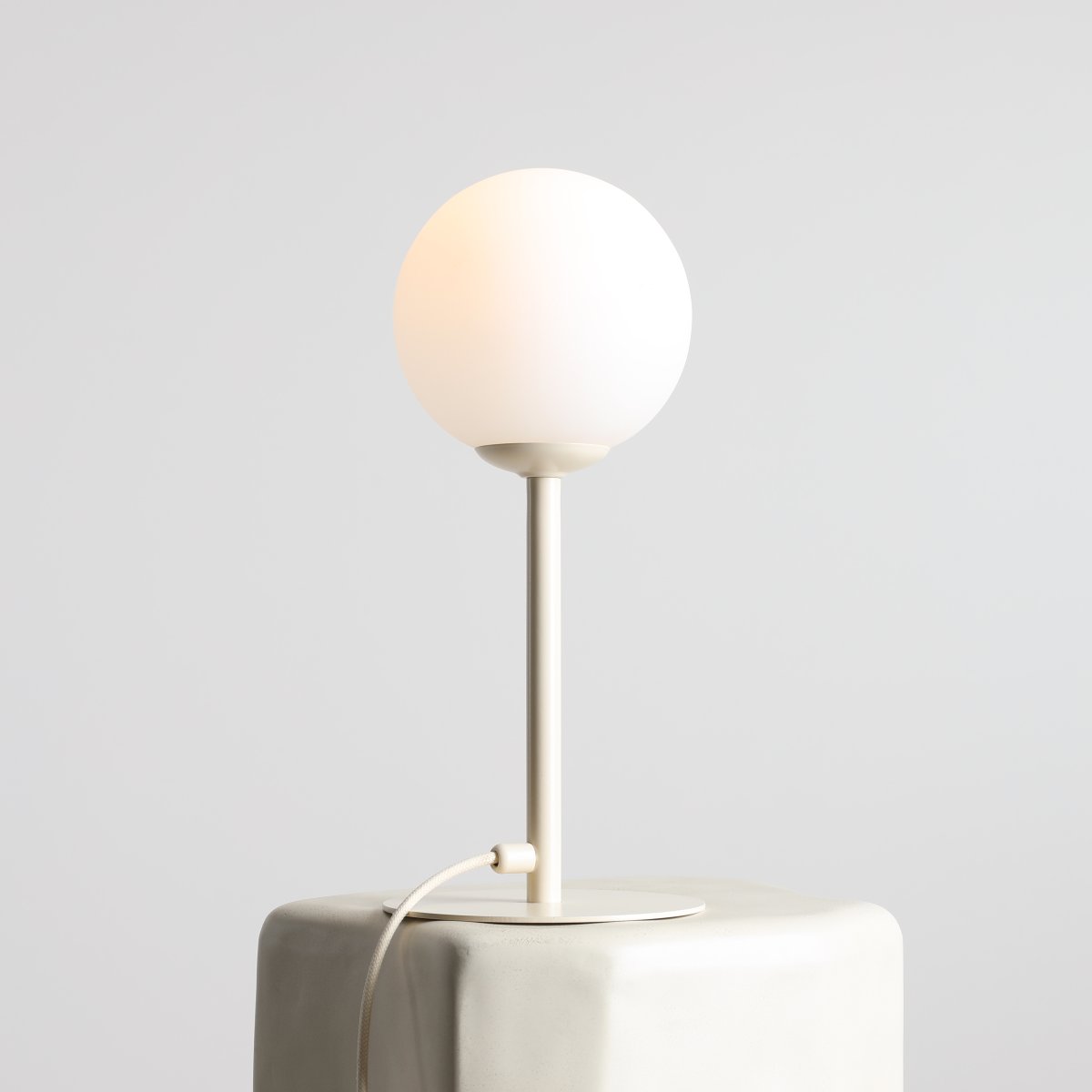 Pinne 35cm Krem bordlampe Fra Artera - Den runde opalgloben sprer et mykt og behagelig lys, perfekt for å skape en varm og innbydende atmosfære i rommet.