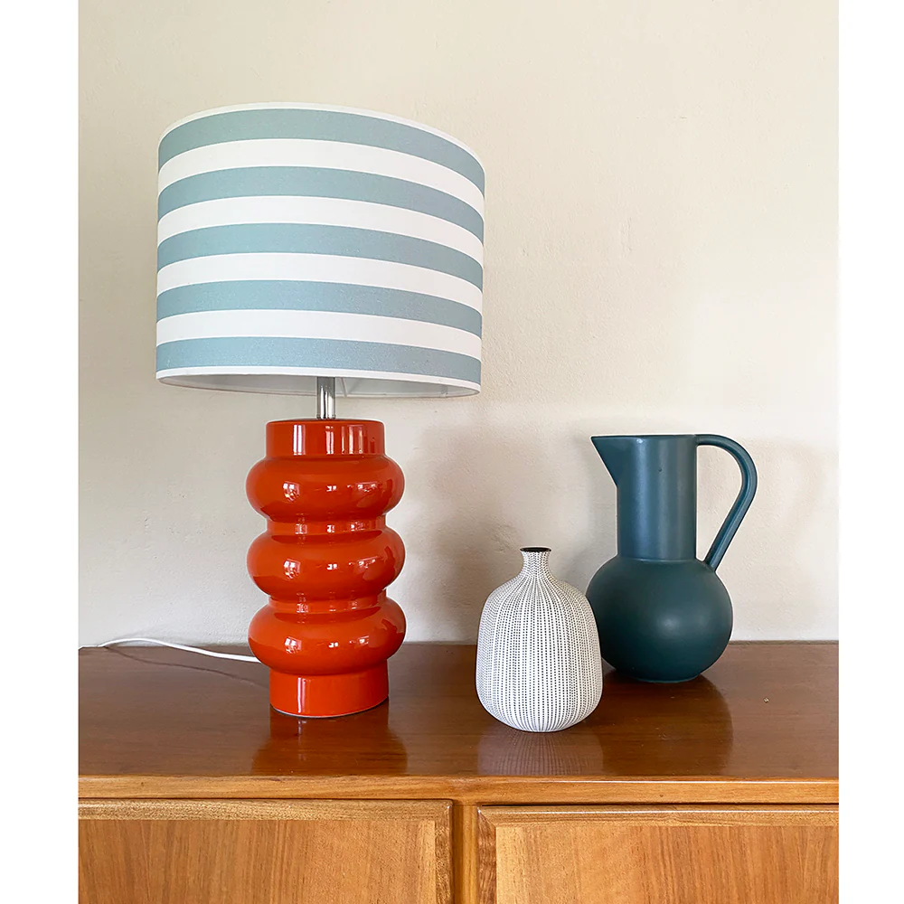 Lyon 56cm Oransje bordlampe Fra Superliving - Med en rikt utformet oransje keramisk base og en stripete nyanse i bl&aring;tt og hvitt, kombinerer Lyon moderne stil med en retro-inspirert f&oslash;lelse.