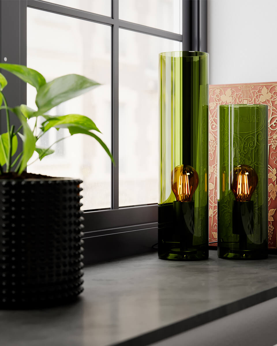 Flake 30cm Grønn bordlampe Fra By Rydéns - Med sitt elegante sylinderformede glass og tilgjengelighet i trendy farger som m&oslash;rk rav og gr&oslash;nt samt hvitt, er Flake den perfekte lampen for &aring; skape stil og atmosf&aelig;re i hjemmet ditt.