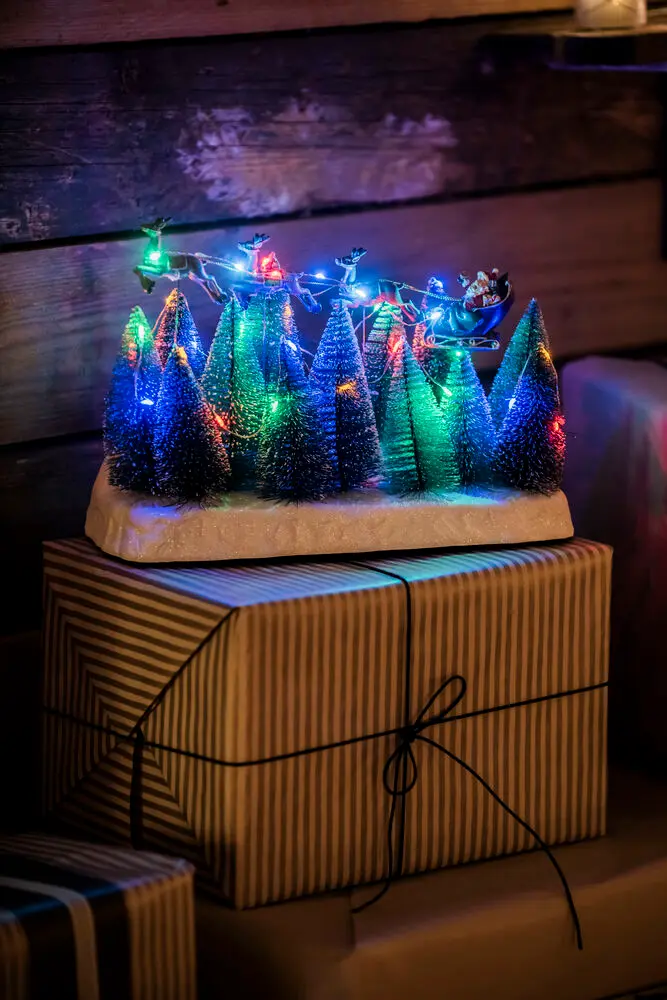 Nisse Med Slede 22cm Flerfarget Fra Konstsmide - Juledekorasjon med julenissen i sn&oslash;drakt som flyr over sn&oslash;dekte grantr&aelig;r.