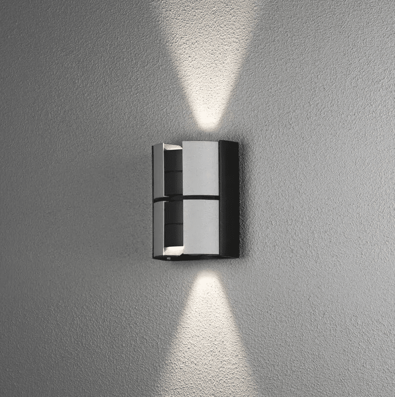 Vidar 15cm Sølv utendørslampe Fra Konstsmide - Lampen lyser opp og ned på veggen og tilbyr justering av lysstrålen slik at du kan justere spredningsgraden du ønsker.