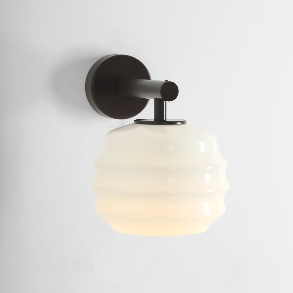 Puff 23cm Mørk brun vegglampe Fra Artera - Den dekorative skjermen i hvitt opalglass har en bølget form som gir lampen et lekent og elegant uttrykk.