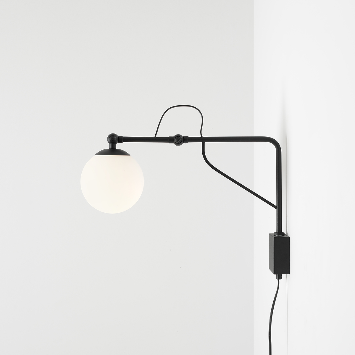 Soho 50cm Svart vegglampe Fra Artera - Lampen har en stilig matt svart metallramme og en opal globus som sprer et mykt, varmt lys, og skaper en innbydende atmosfære i alle rom.