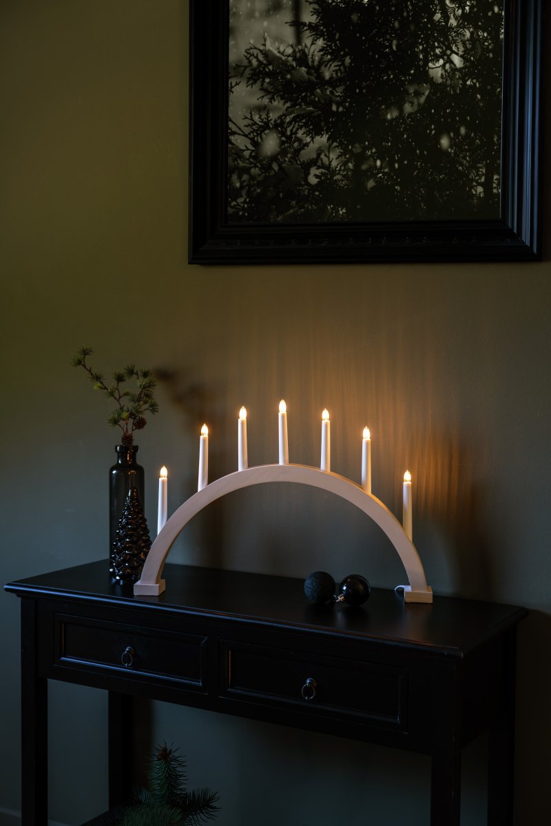 Arch 7 Lights Hvit Fra Konstsmide - Rammen er laget av tre med en hvitbeiset overflate som gir et naturlig og tidl&oslash;st utseende.