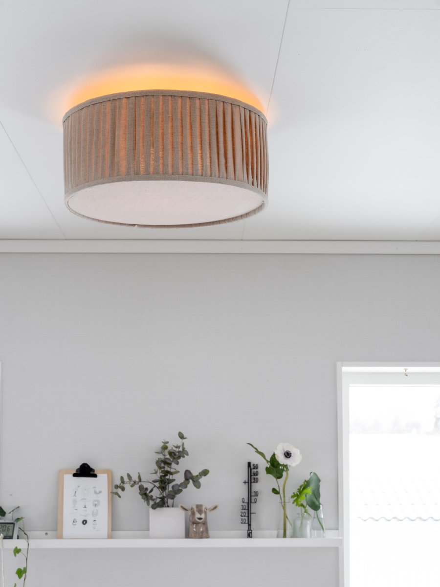 Plissé Ø45 Beige plafond Fra PR Home - Lampen er utstyrt med blendbeskyttelse nederst for et jevnt og behagelig lys uten gjenskinn.