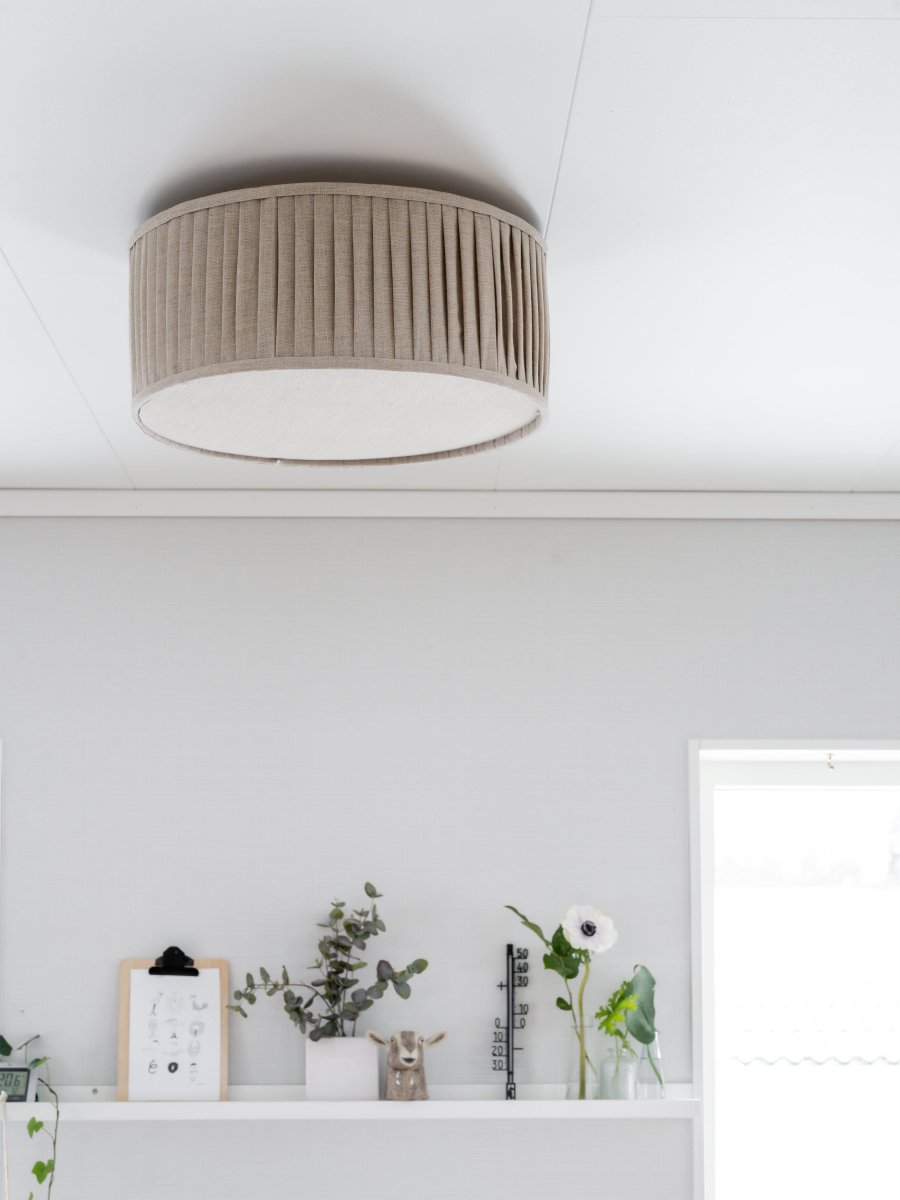 Plissé Ø45 Beige plafond Fra PR Home - Lampen er utstyrt med blendbeskyttelse nederst for et jevnt og behagelig lys uten gjenskinn.