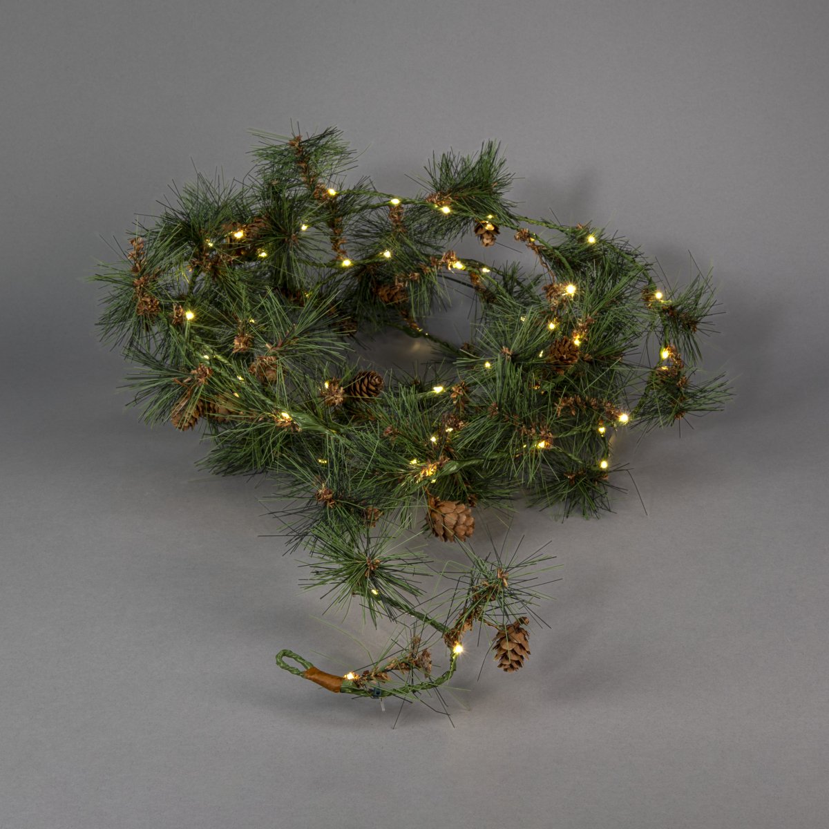 Girlander 6m Grønn Fra Konstsmide - Skap en varm og innbydende vinterf&oslash;lelse med denne girlanderen med kunstige furun&aring;ler og sm&aring; kongler.