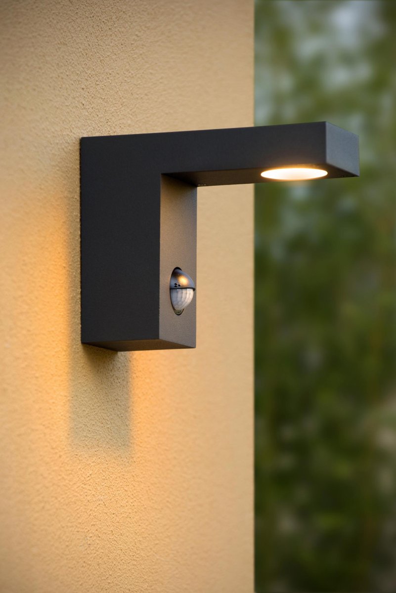 Texas-Ir Antrasitt utendørslampe Fra Lucide - Denne utendørs vegglampen, med integrert bevegelsessensor og dag/natt sensor, har allerede blitt en klassiker.