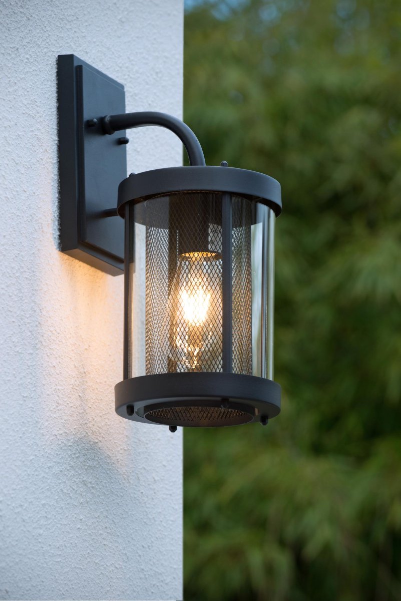 Makkum Svart utendørslampe Fra Lucide - Lampen er innelukket i et metallrør og omgitt av en glasslanterne, som skaper en naturlig og atmosfærisk lysspredning.