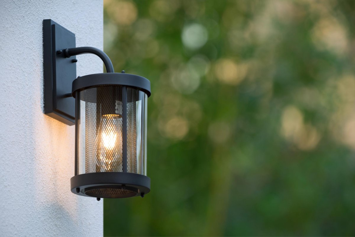 Makkum Svart utendørslampe Fra Lucide - Lampen er innelukket i et metallrør og omgitt av en glasslanterne, som skaper en naturlig og atmosfærisk lysspredning.