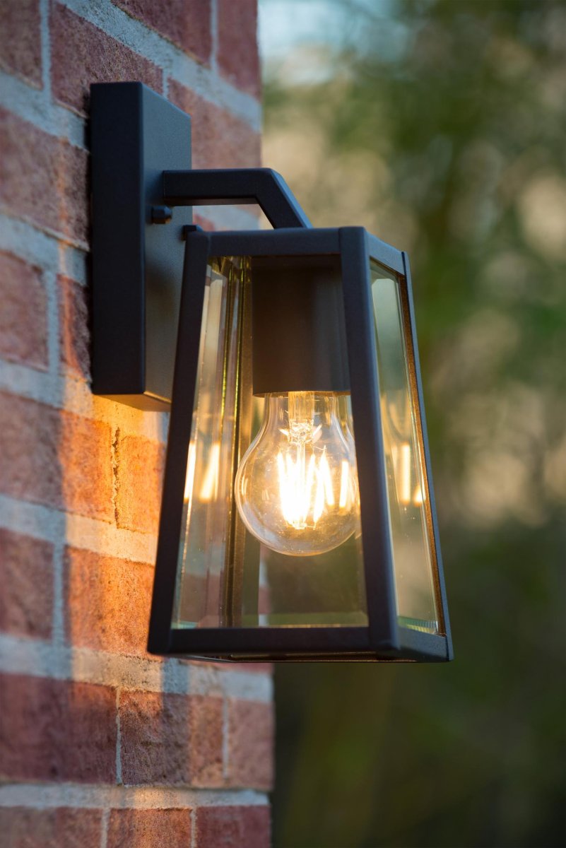 Matslot Svart utendørslampe Fra Lucide - Den rustikke formen og den tydelige referansen til en klassisk lanterne smelter sammen med en moderne finish og et karakteristisk håndverkerpreg.
