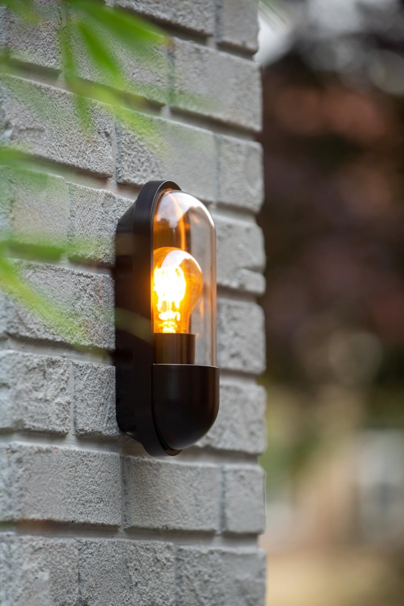 Capsule Svart utendørslampe Fra Lucide - Vegglampen er nesten 10 centimeter lang og 24 centimeter h&oslash;y og kan enkelt styres via en lysbryter.