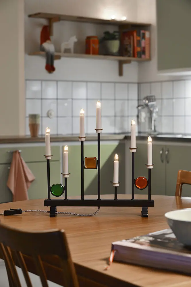 Candelabra 7 Lights Svart Fra Konstsmide - De syv lysene er innrammet av dekorative fargede glassdetaljer i gr&oslash;nt, r&oslash;dt og rav, som skaper en elegant og festlig atmosf&aelig;re.