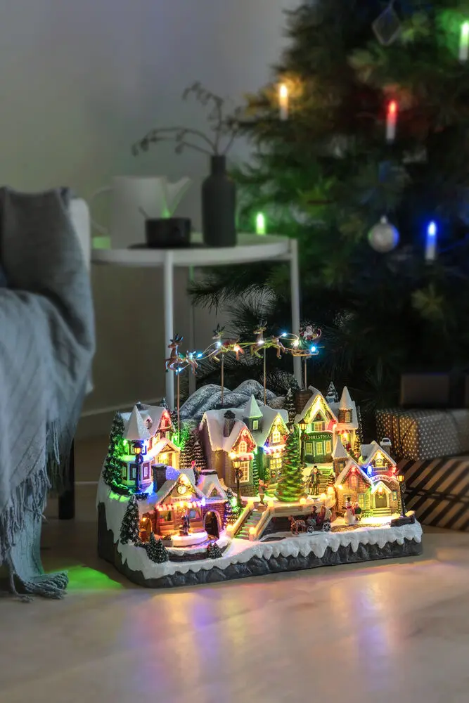 Mekanisk Juledekorasjon Med By Og Tog 40cm Flerfarget Fra Konstsmide - Fantastisk julelandsby med bevegelige deler, fargerike tog og 52 str&aring;lende LED-lys som lyser opp hver eneste detalj.