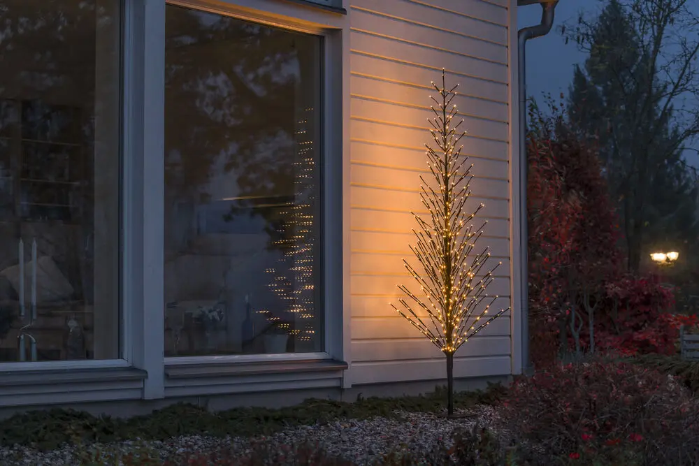 Svart Tre 210cm Svart Fra Konstsmide - Et elegant svart dekorativt tre som lyser opp vinteren med 504 varme ravfargede LED-lys i jevn og ildflueeffekt.